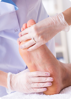 Professionista sanitario esegue bendaggio o esame sul piede, mani guanti, contesto clinico chiaro.